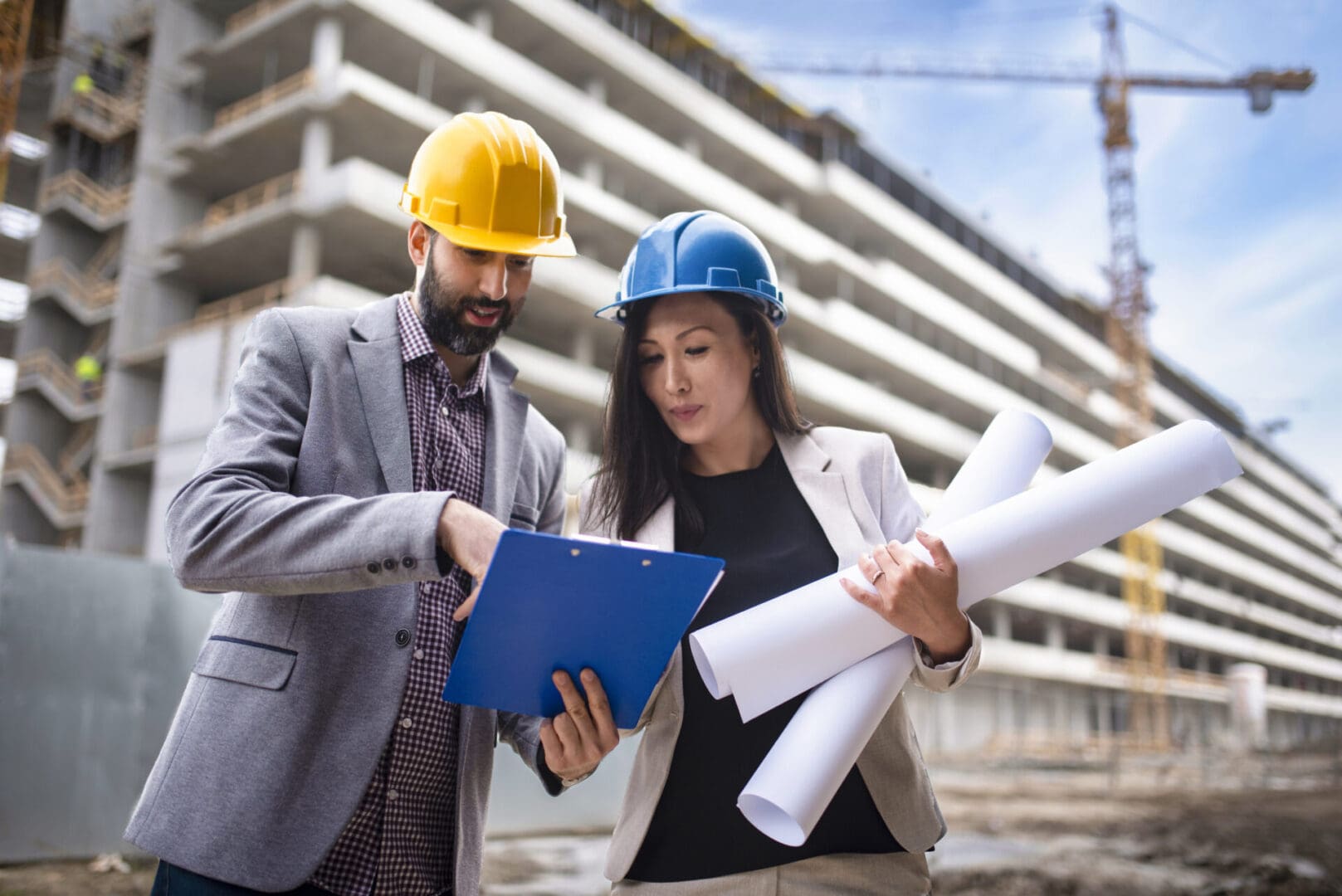 Construction workers reviewing plans at site.