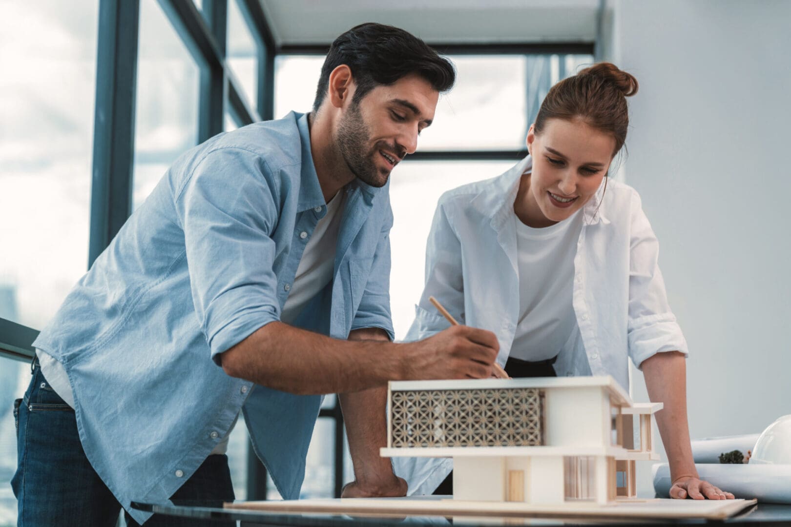 Architects discussing a scale model building.
