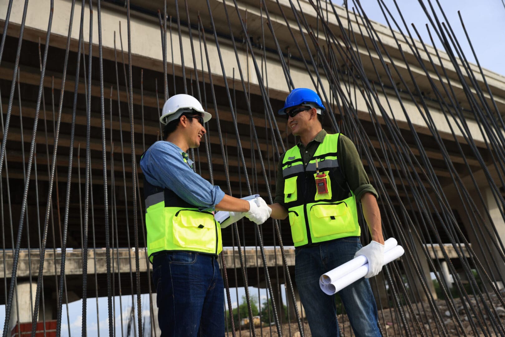 Construction workers shaking hands at site.