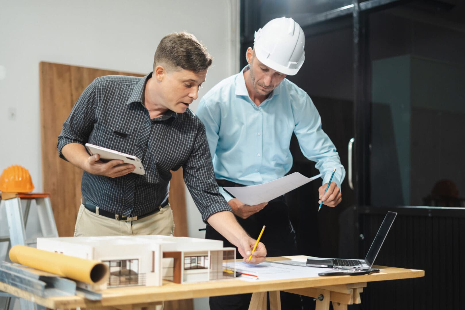 Two architects reviewing building plans together.